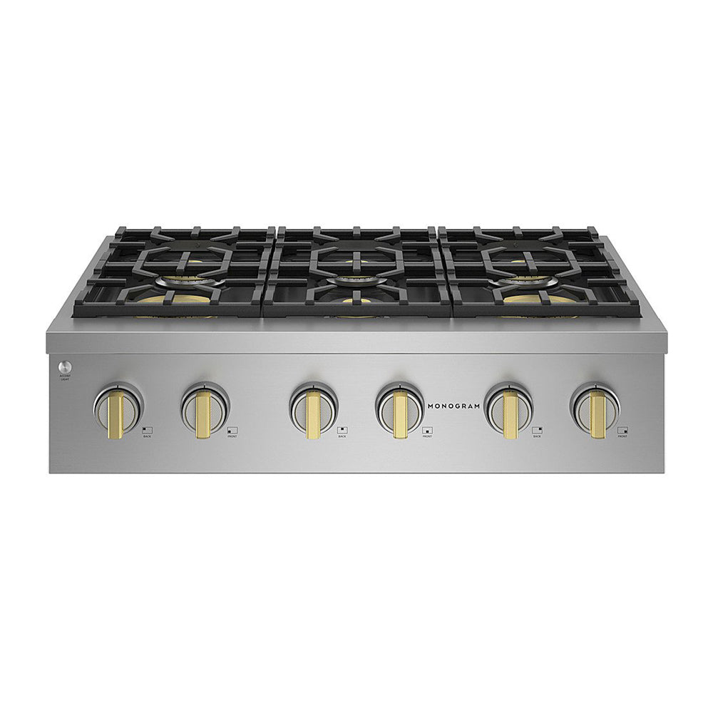 Stainless steel cooktop with six gas burners and brass control knobs