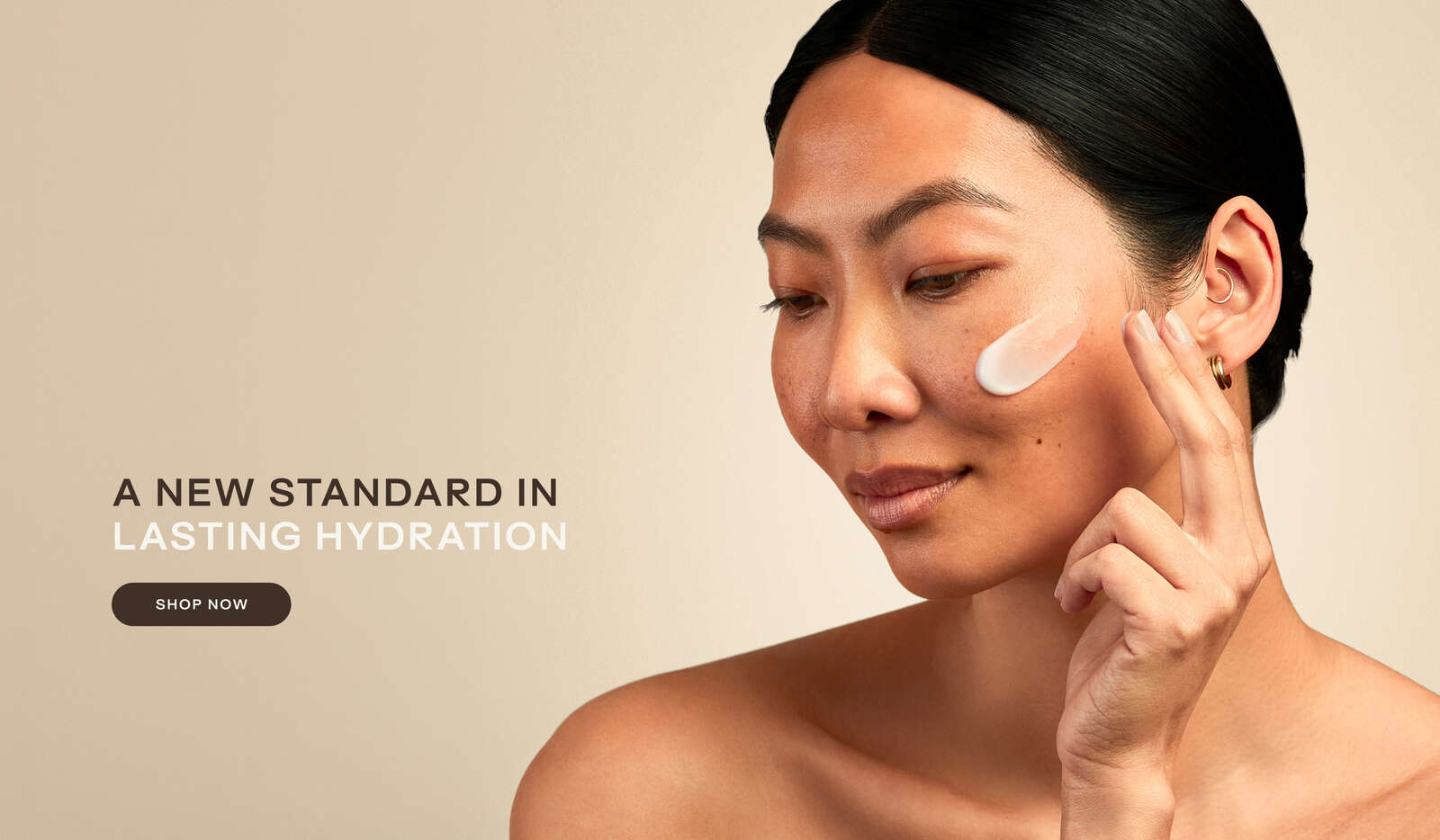 Woman applying white cream to her cheek with text 'A NEW STANDARD IN LASTING HYDRATION'