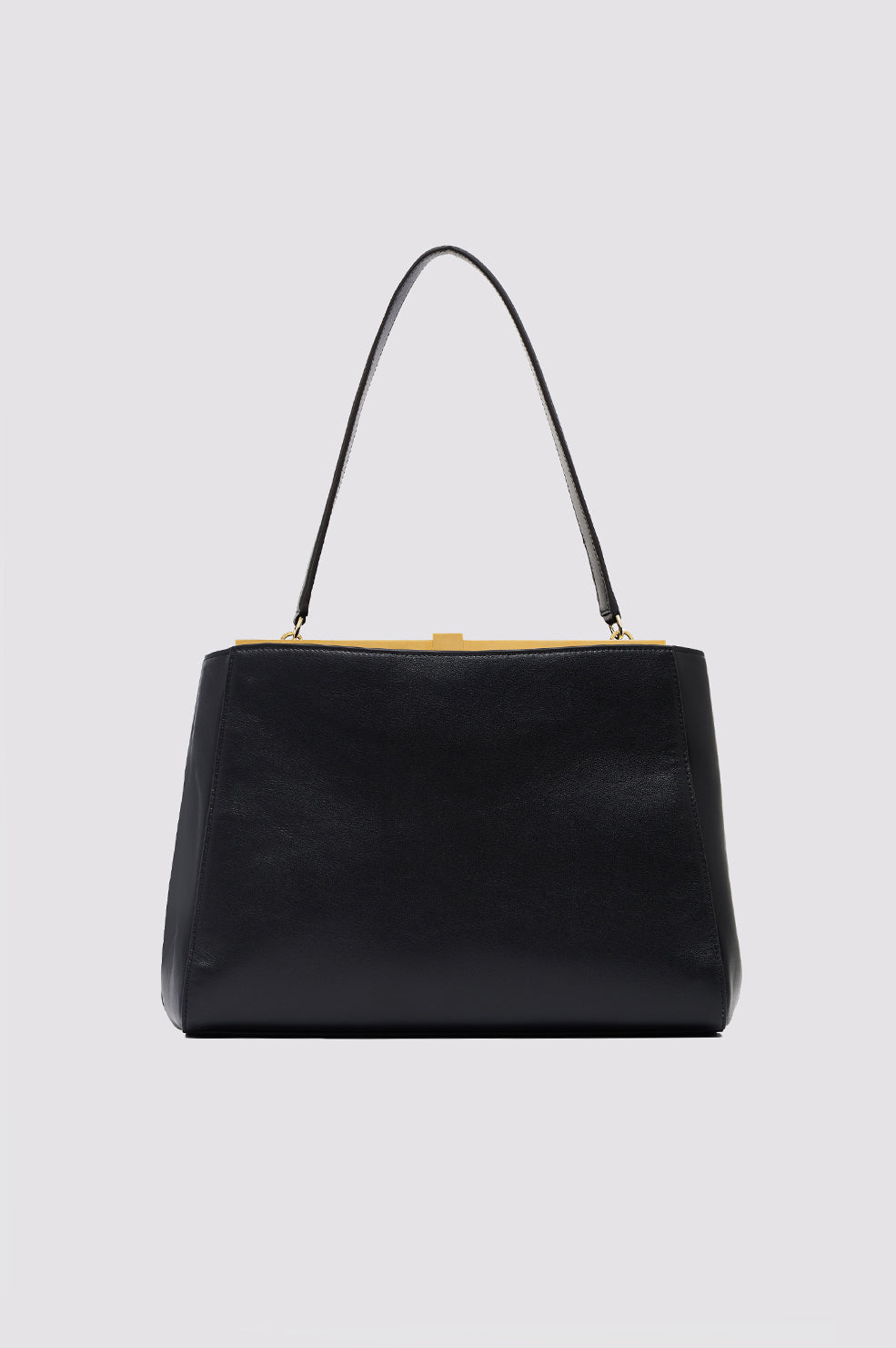 Black leather shoulder bag with gold-tone metal frame and handles on light gray background