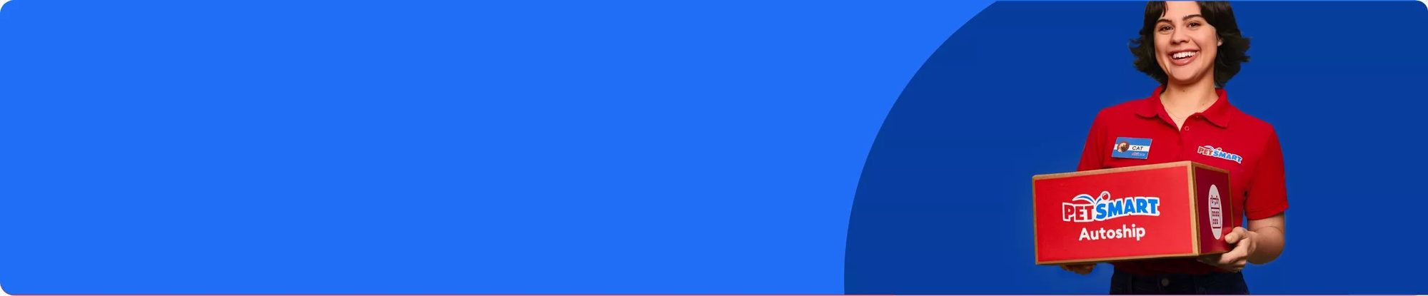 Employee in red PetSmart uniform holding a red Autoship box against blue background