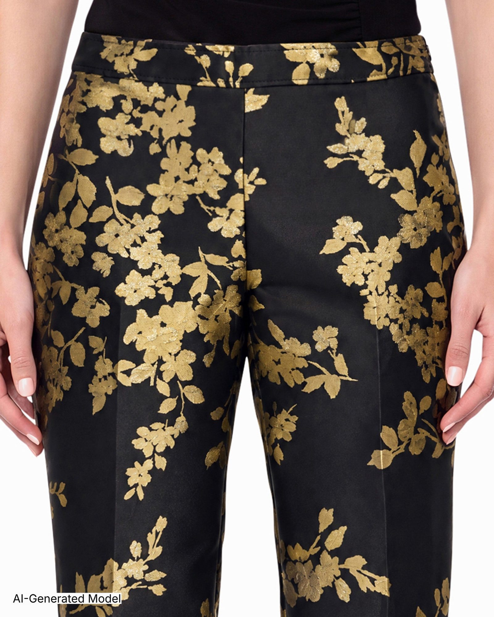 Close-up of black pants waistband and thighs with gold leaf and flower print