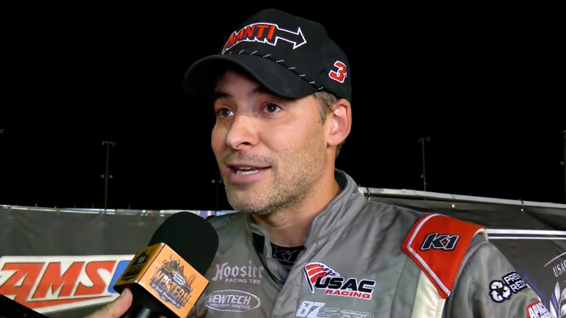 Racing driver being interviewed at trackside with microphone after event