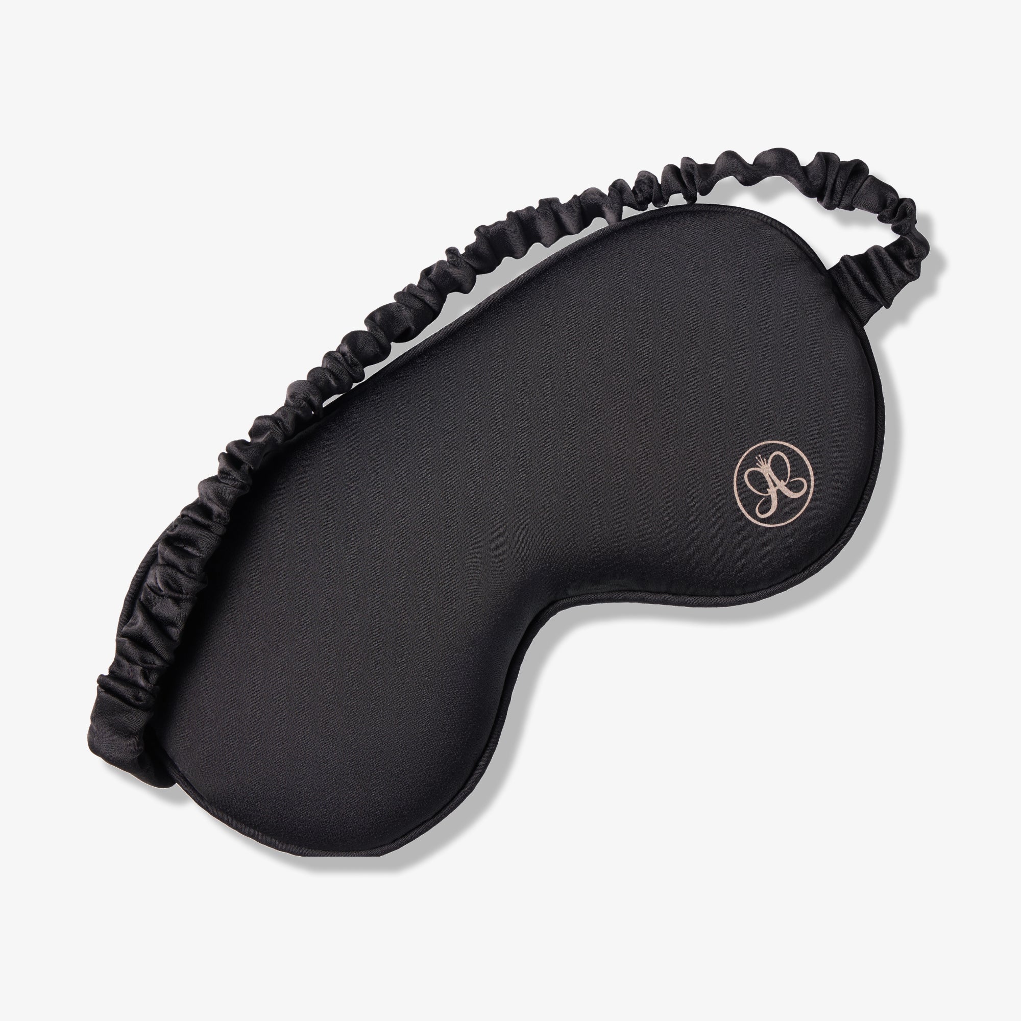 Black contoured sleep mask with elastic headband and rose gold logo detail