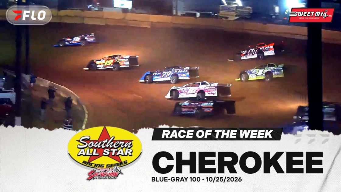 Dirt track racing cars kicking up dust cloud during night race competition