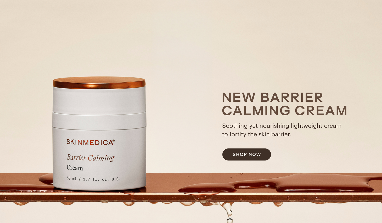 White jar with copper lid labeled 'Barrier Calming Cream' on bronze surface with water droplets