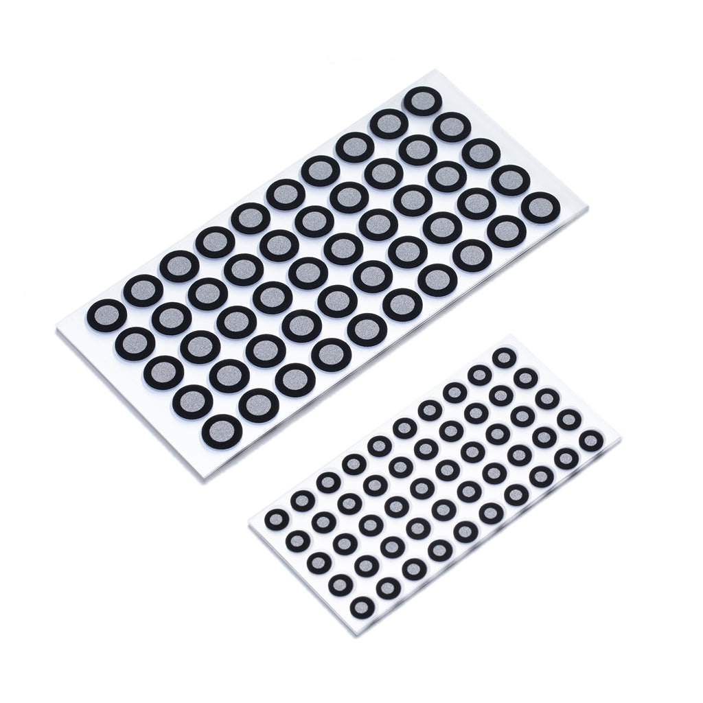 Two sheets of varying-sized circular rubber gaskets arranged on white adhesive backing strips