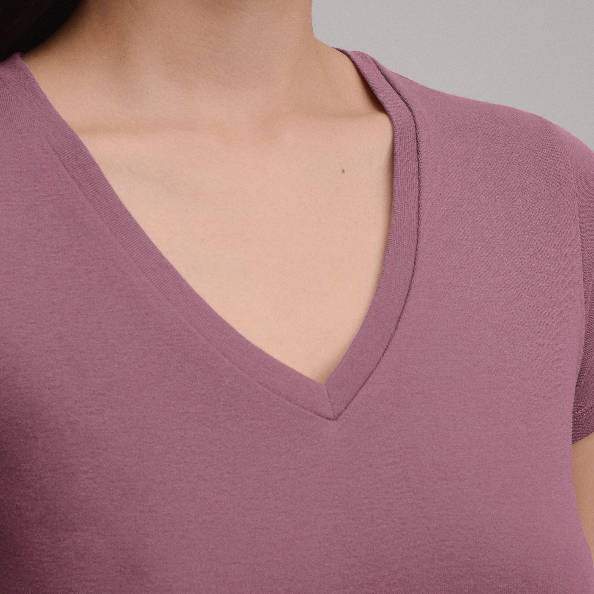 Close-up of mauve v-neck t-shirt showing neckline and fabric texture on chest