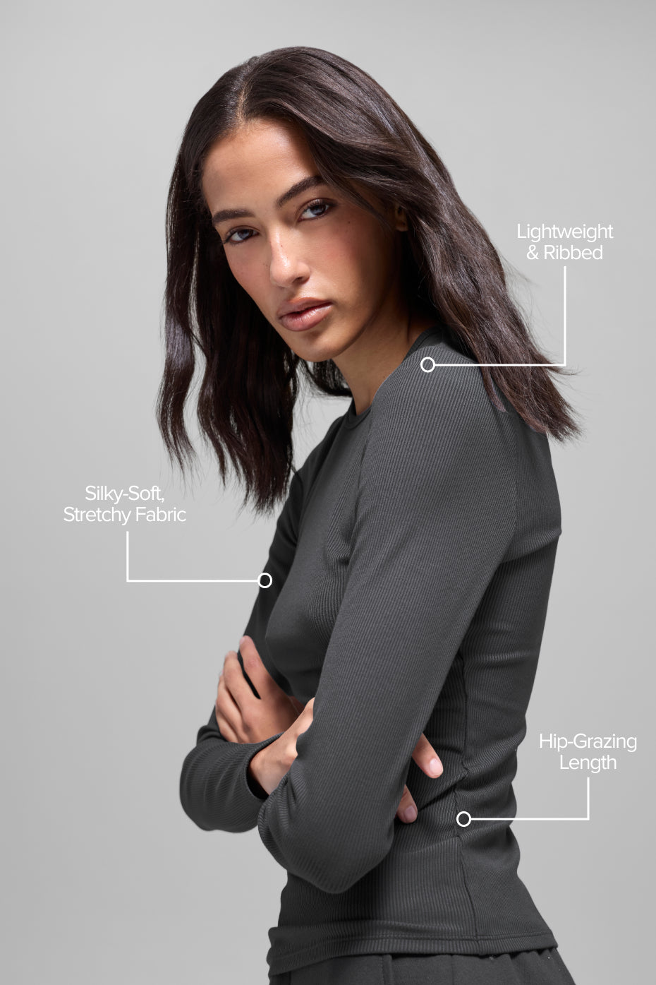 Woman wearing charcoal ribbed blazer with long sleeves over black shirt, demonstrating lightweight and stretchy layering piece
