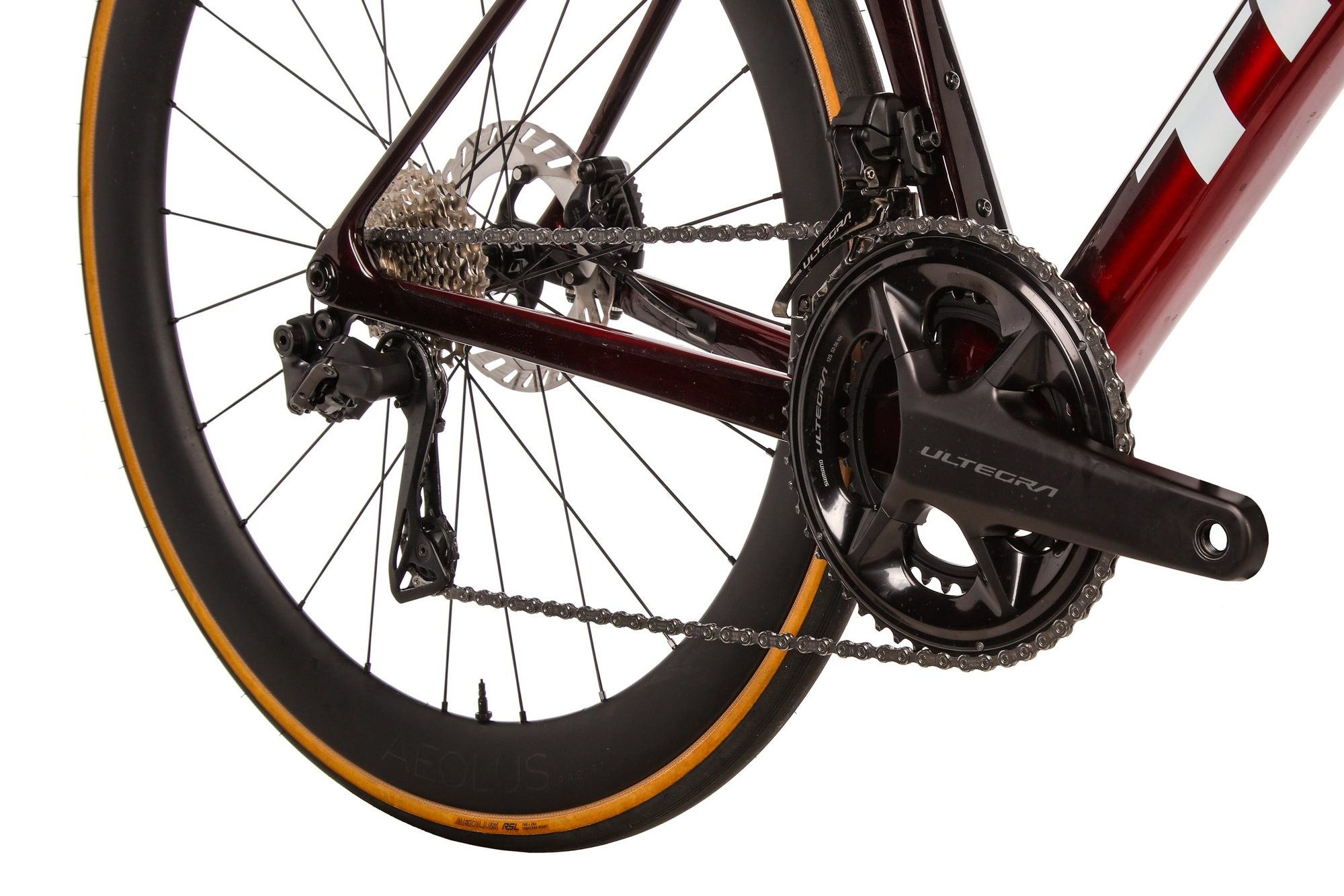 Close-up of bike drivetrain and chain with gold-rimmed black tire visible