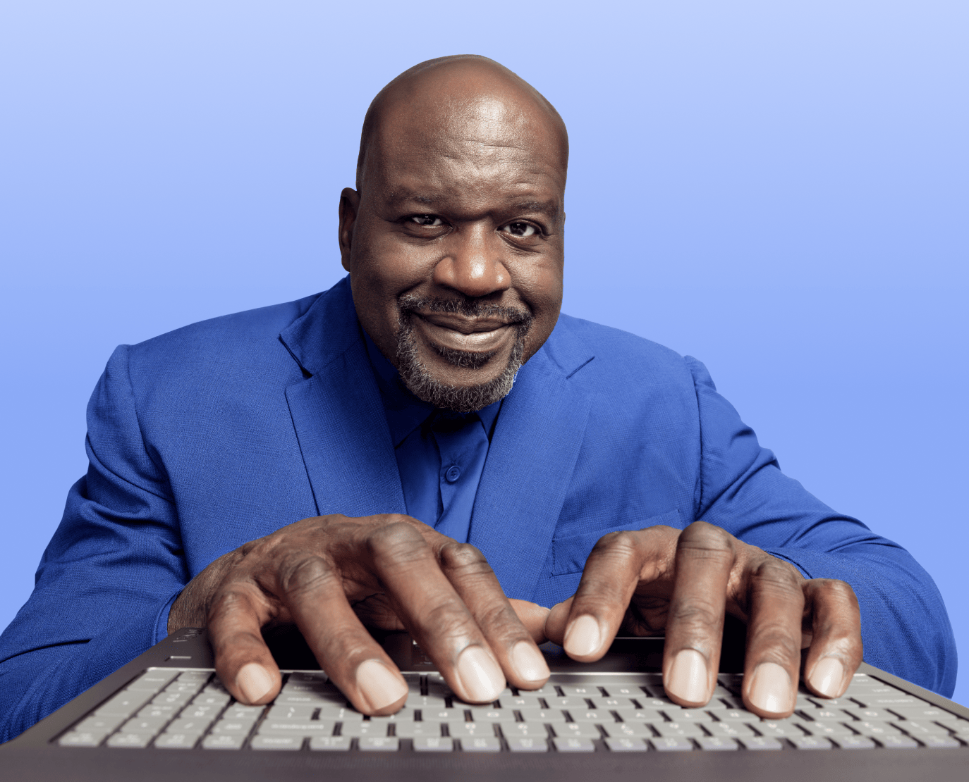 Man in blue shirt typing on computer keyboard against blue background