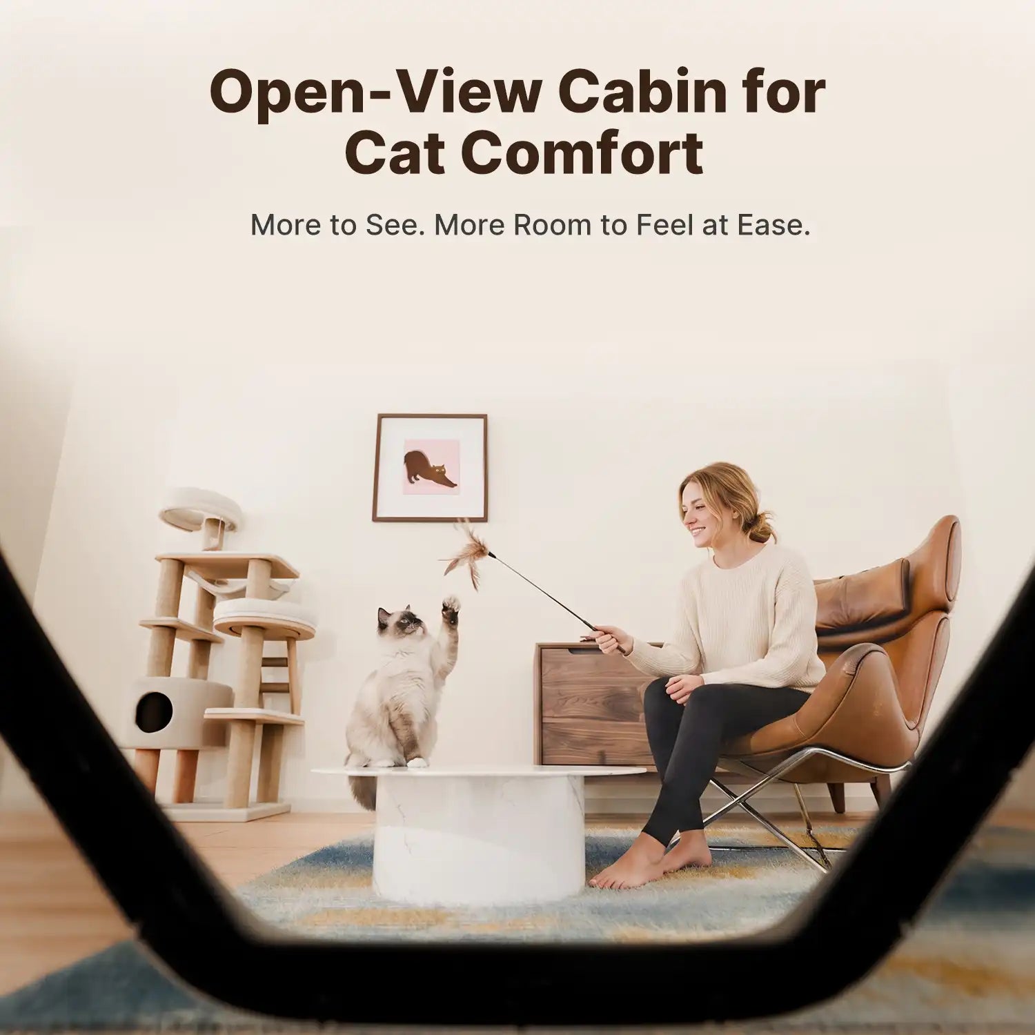 Woman playing with cats inside a home, viewed through open cabin entrance of litter box