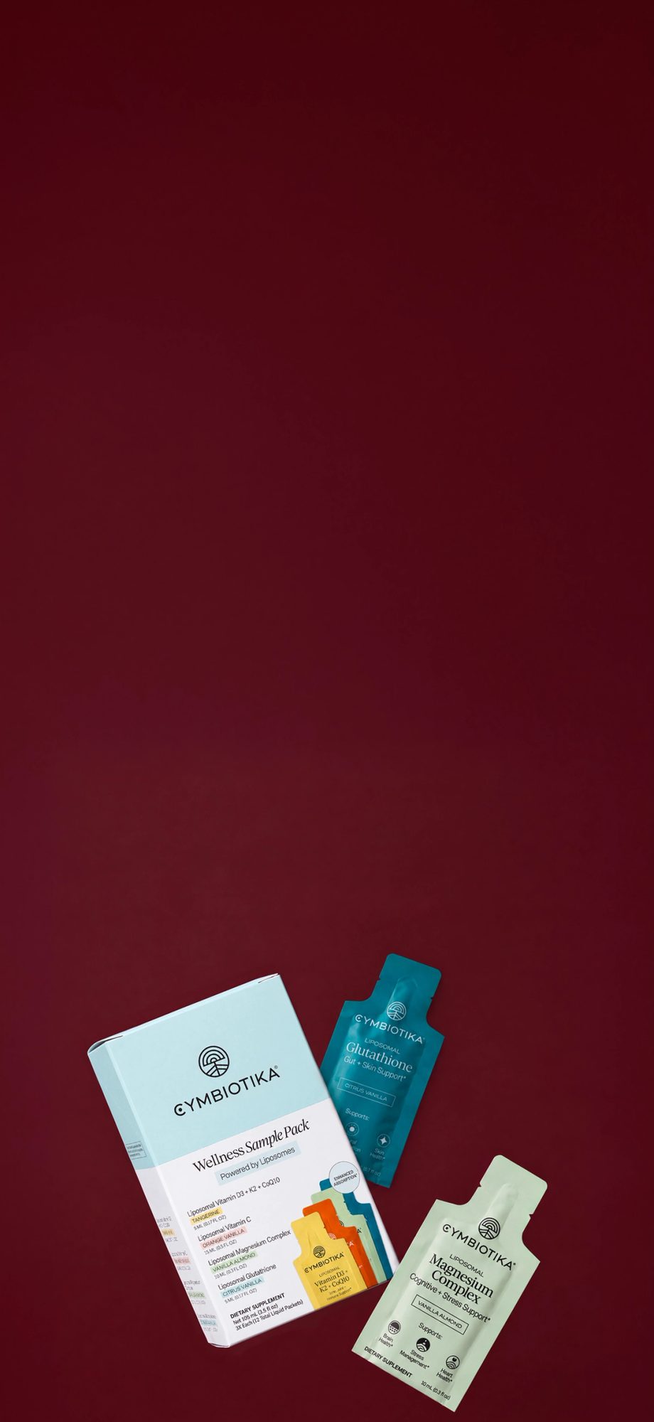 Wellness sample pack and individual supplement pouches on burgundy background