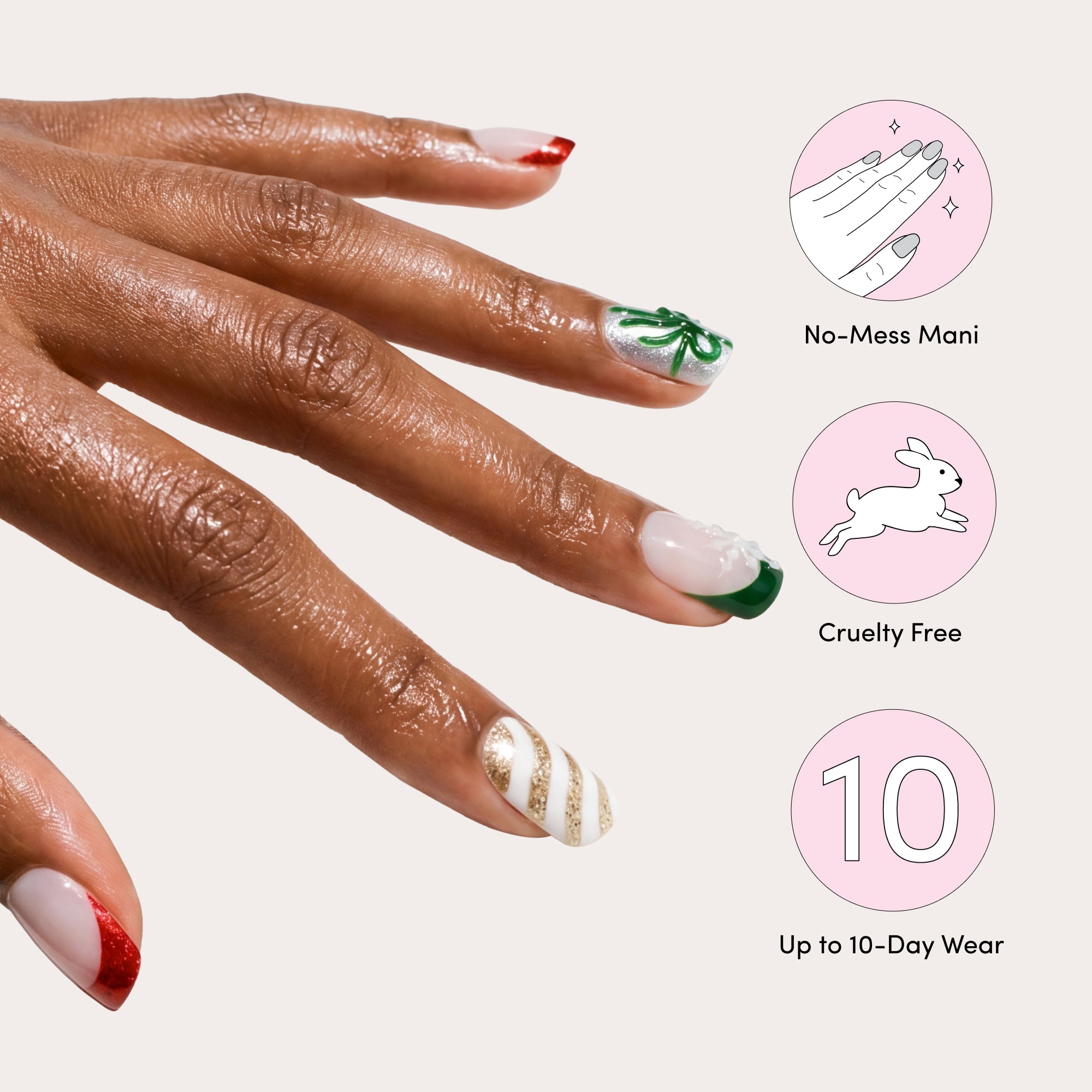 Finished press-on nails on hand displaying red, green, and gold designs