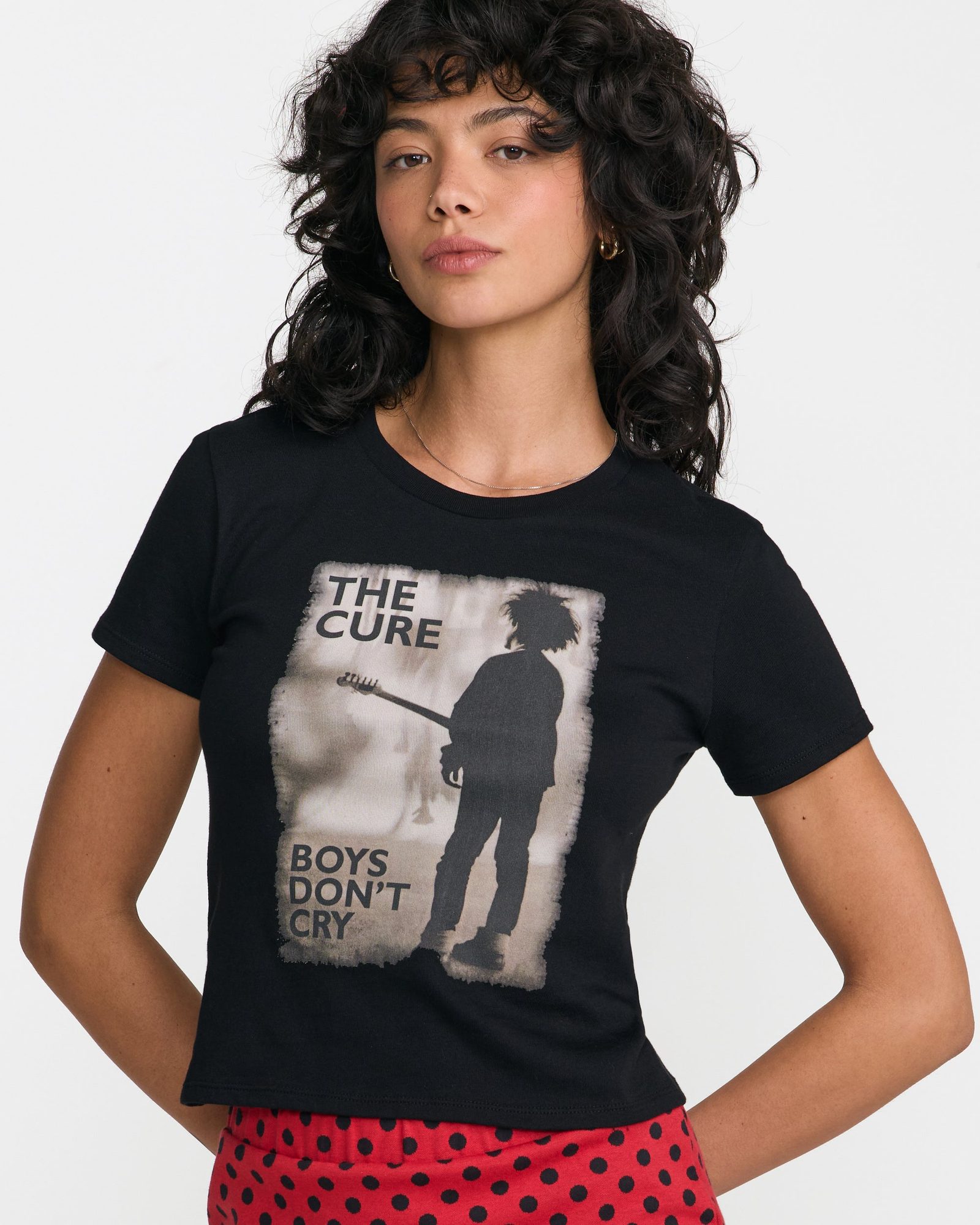 Woman wearing black t-shirt with The Cure 'Boys Don't Cry' album artwork and red polka dot pants