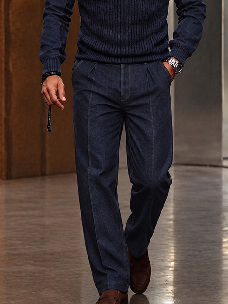 Close-up of man's lower body in navy ribbed sweater and coordinating navy pleated trousers with brown shoes