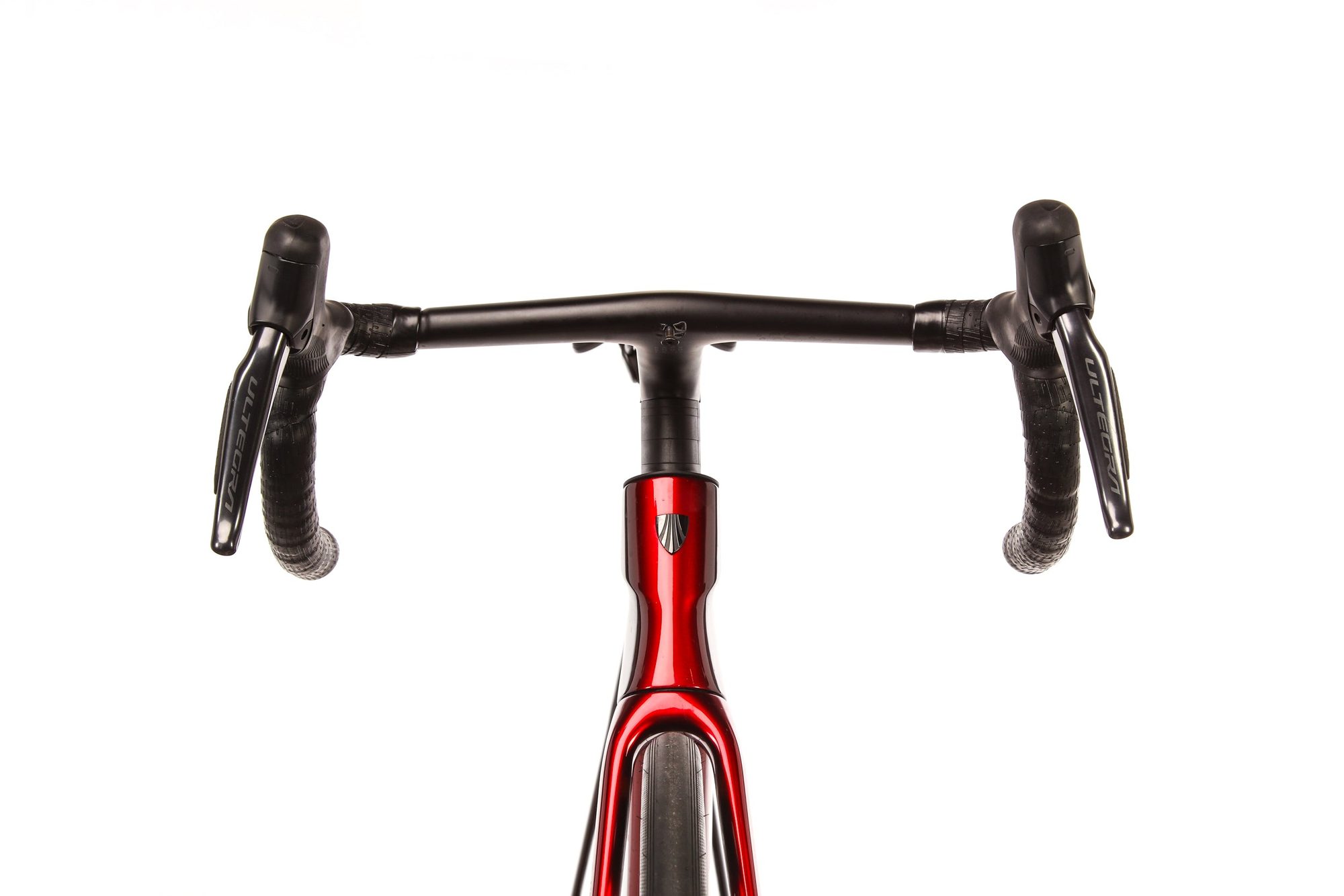 Handlebar and stem of red bike with drop bars and shift levers viewed from above