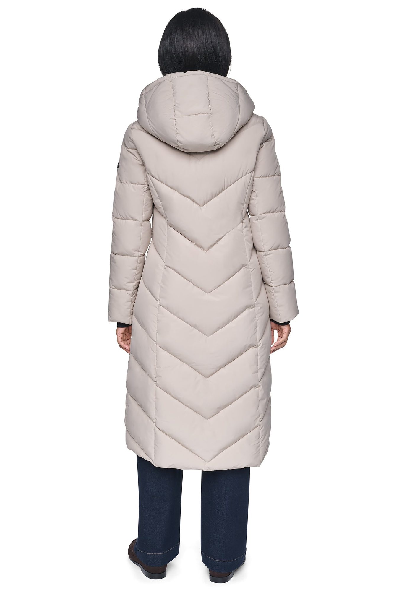 Back view of woman in beige quilted long puffer coat with chevron stitching pattern and hood
